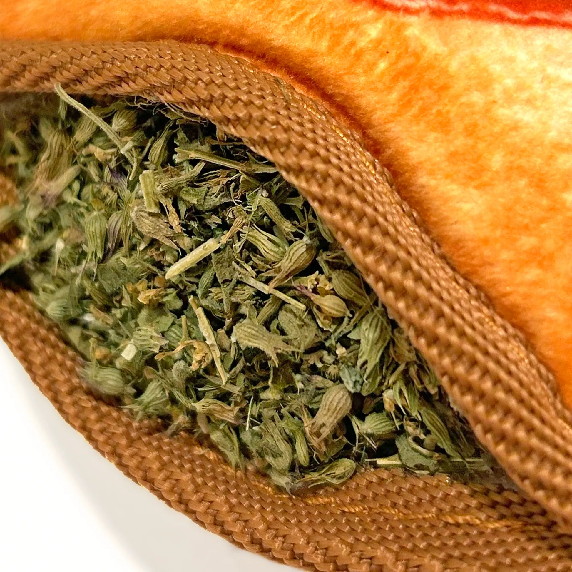 Close-up of Juananip stuffed inside the refillable pocket of the Corn Dog toy, highlighting the herb's quality.